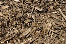 A pile of wood chips sitting on top of a pile of dirt.