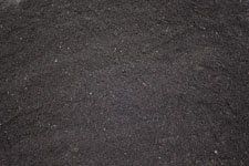 A pile of black gravel is sitting on the ground.