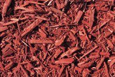 A pile of red mulch is sitting on the ground.