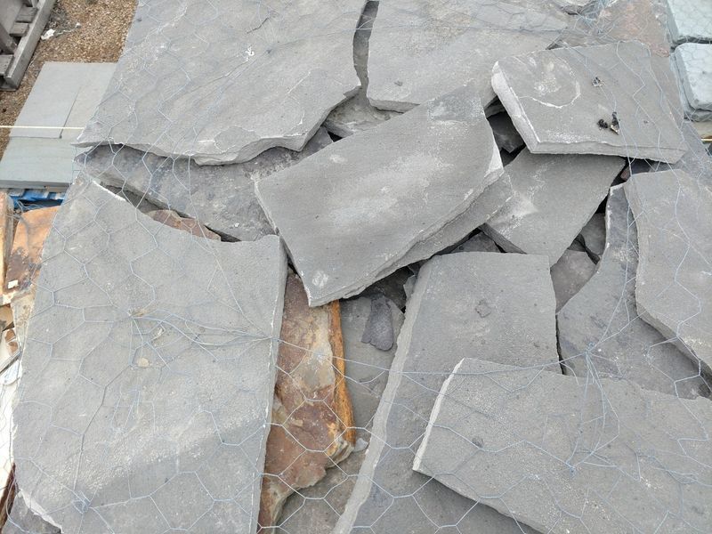 A pile of rocks is sitting on top of a chicken wire fence.