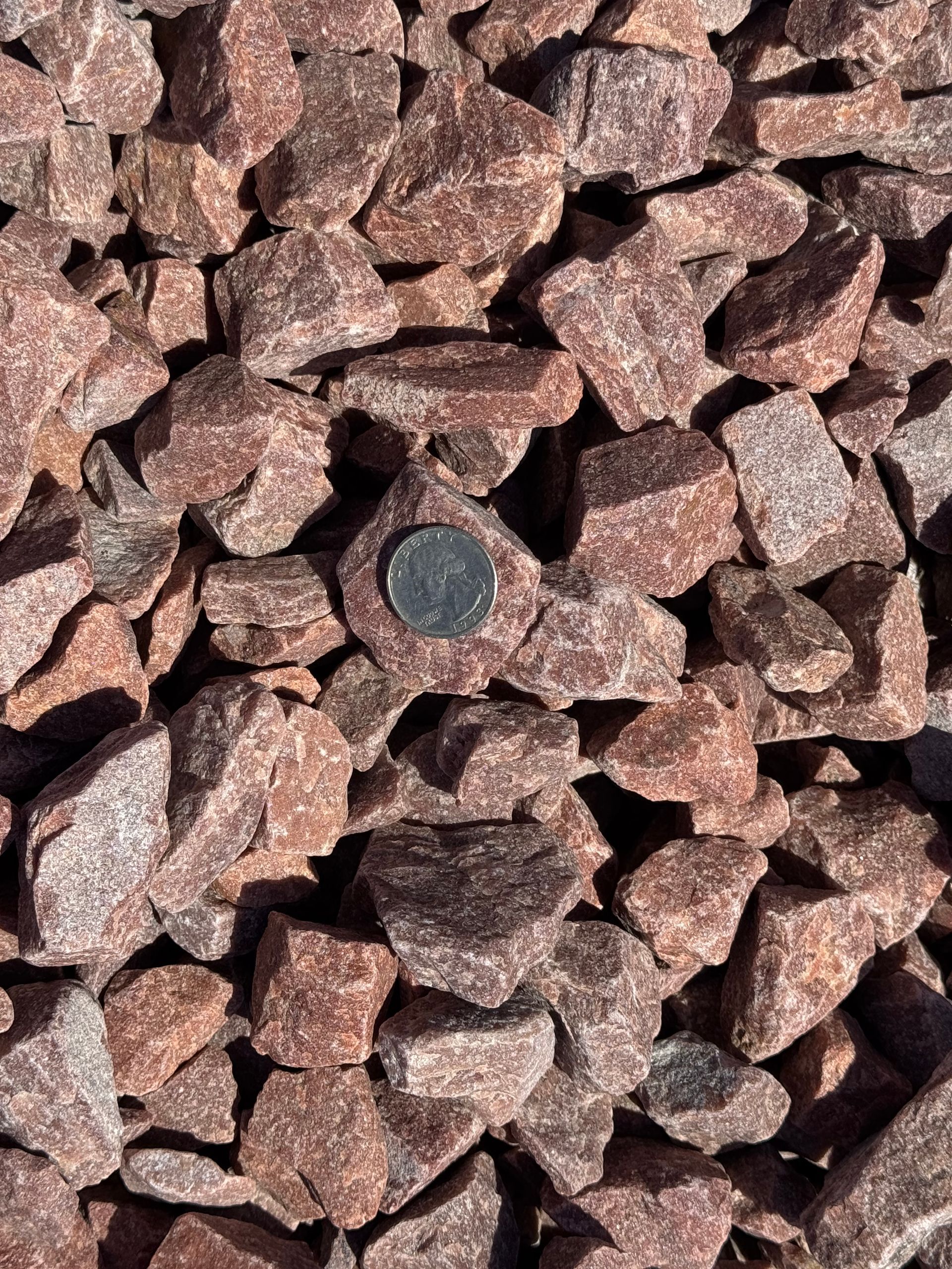 A pile of pink gravel is sitting on the ground.