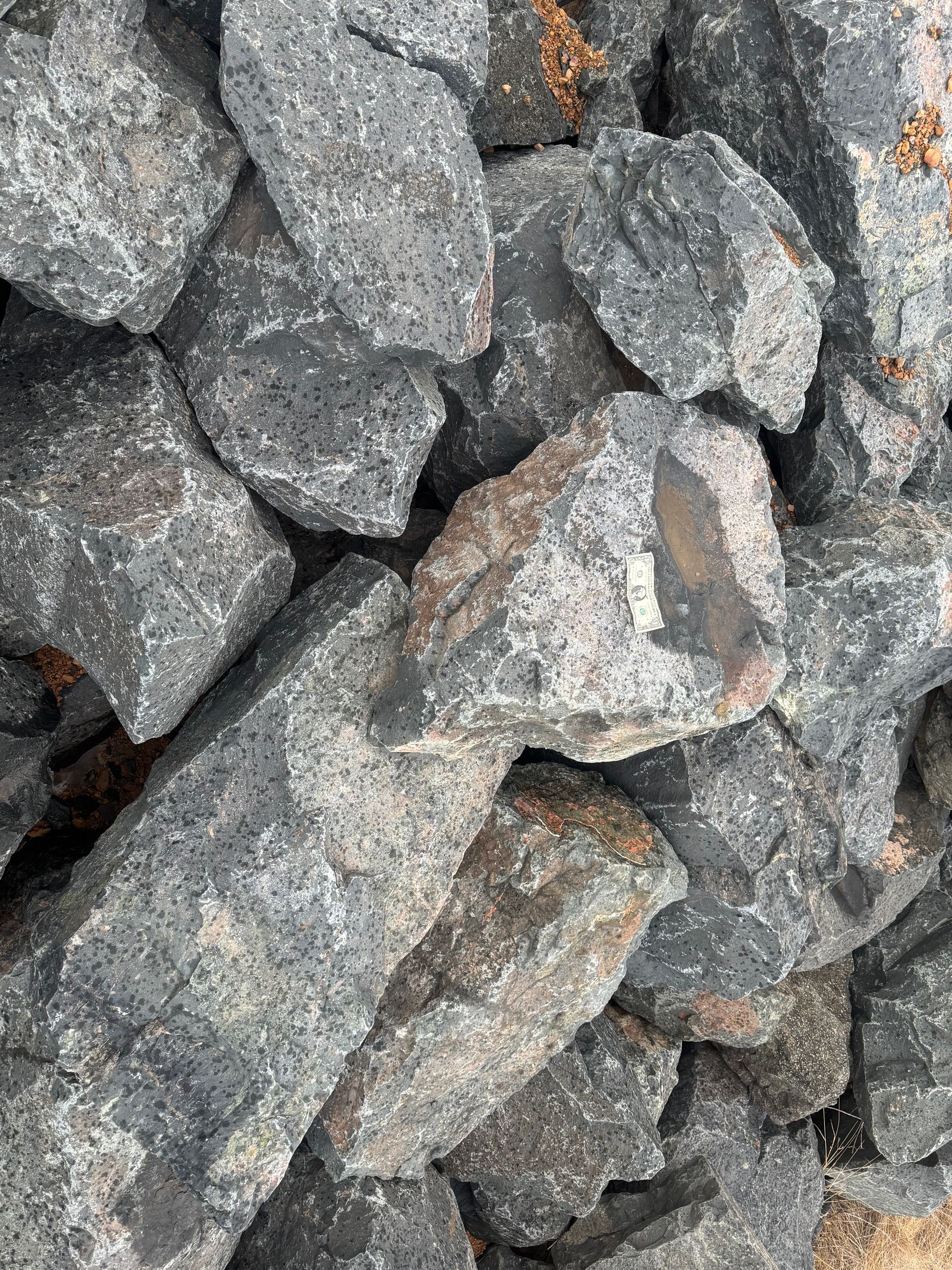 A pile of rocks sitting on top of each other in a field.