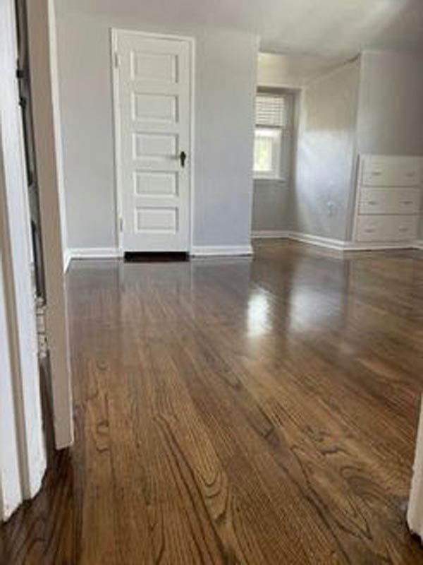 A living room with hardwood floors and a white door.