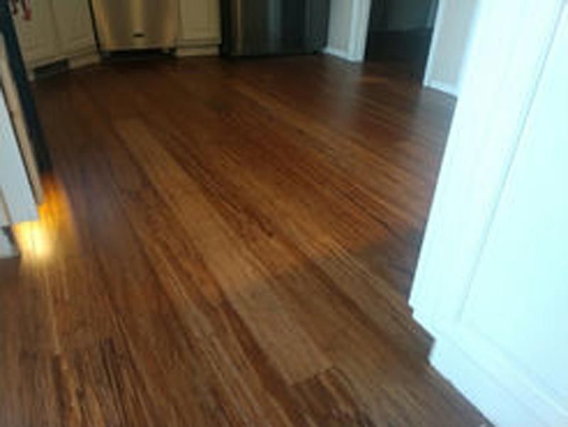 A close up of a wooden floor in a kitchen.