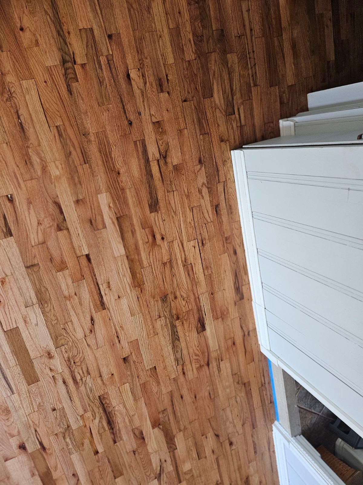 A close up of a wooden floor in a room with stairs
