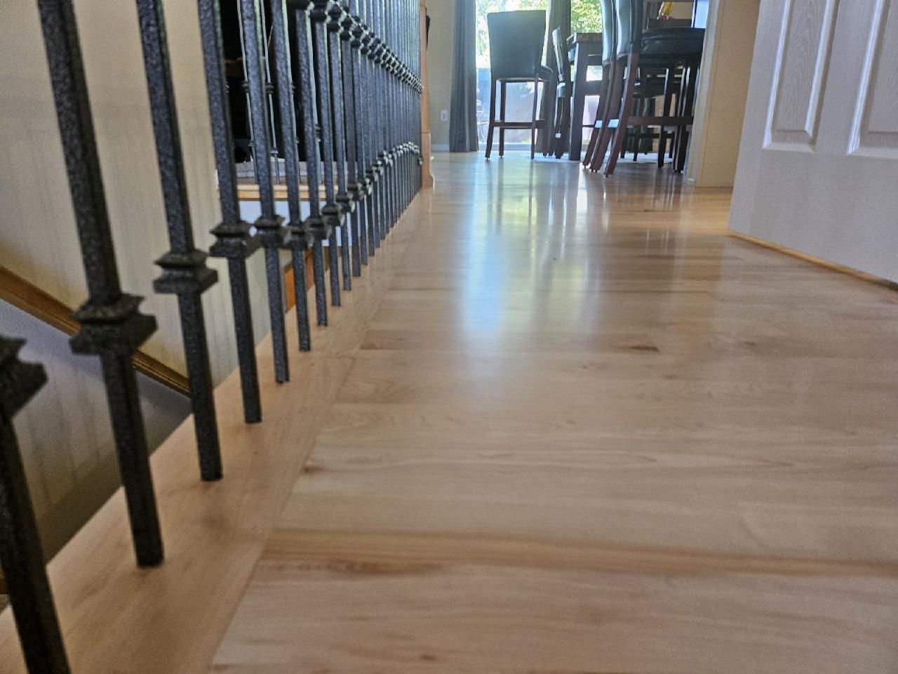 A wooden floor with a metal railing and stairs in a house