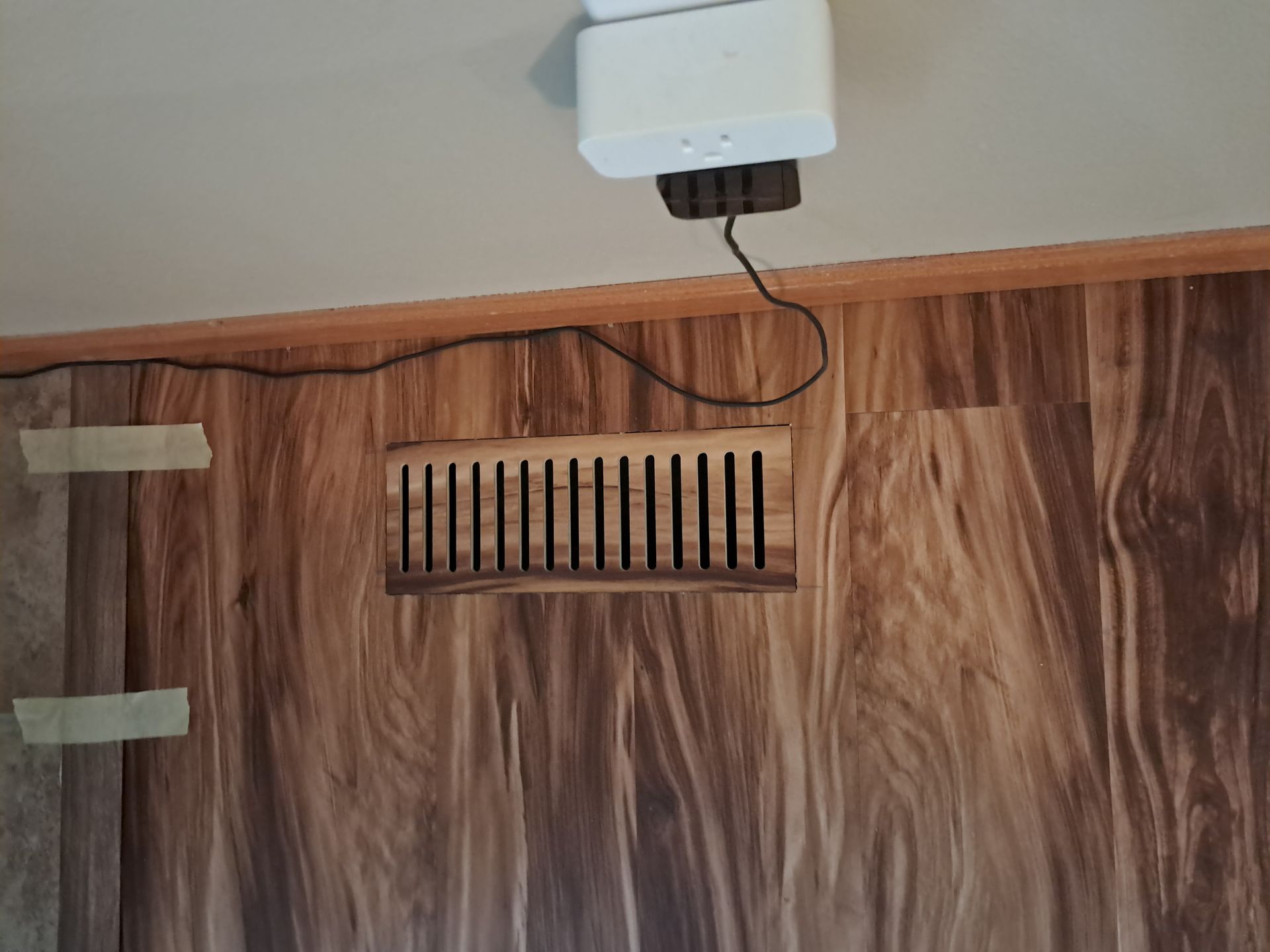 A wooden wall with a vent on it