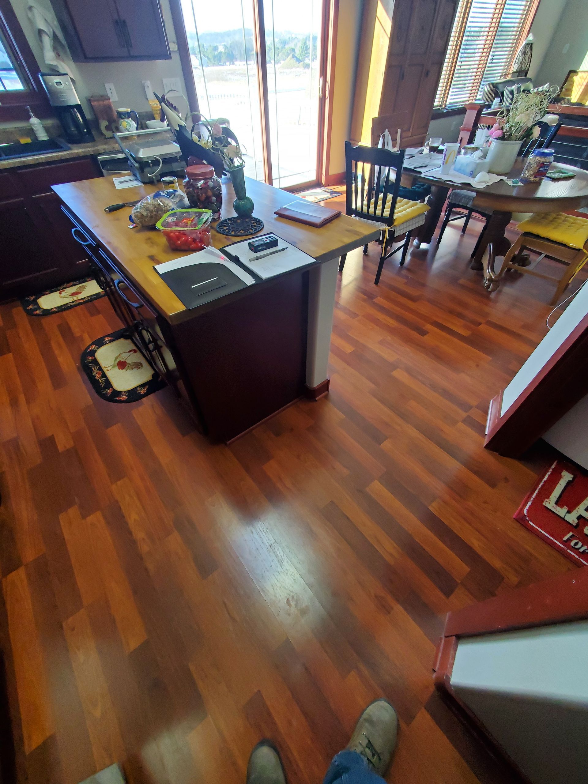 A kitchen with hardwood floors and a table and chairs