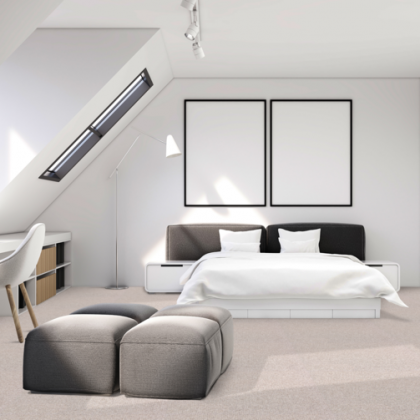 A bedroom with a large bed and two ottomans