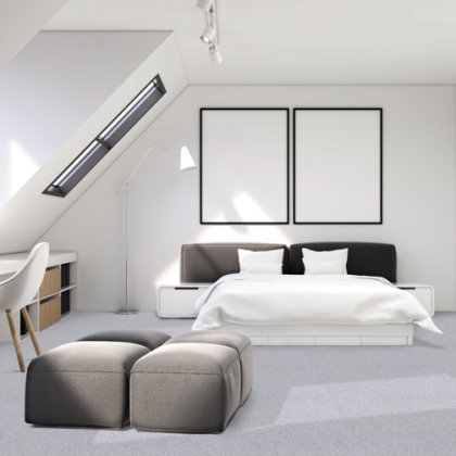 A bedroom with a large bed and two ottomans