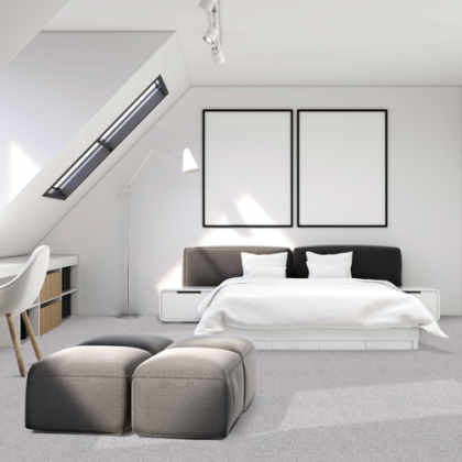 A bedroom with a large bed and two ottomans