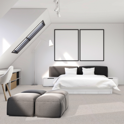 A bedroom with a large bed and two ottomans