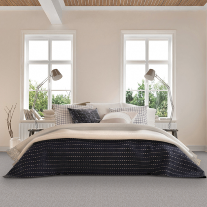 A bedroom with a bed , two lamps and two windows.