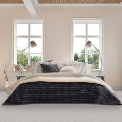 A bedroom with a bed , two lamps and two windows.