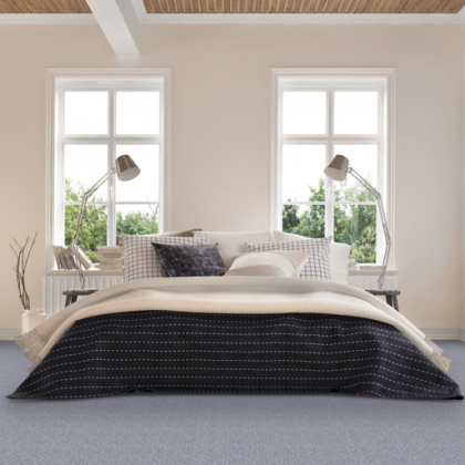 A bedroom with a bed , two lamps , and two windows.