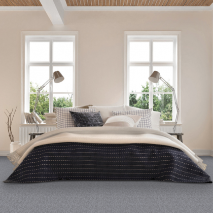 A bedroom with a bed , two lamps , and two windows.