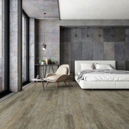 A bedroom with a bed , chair , table and large windows.