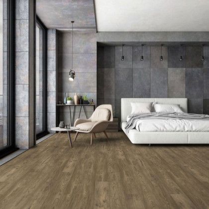 A bedroom with a bed , chair , table and large windows.