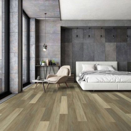A bedroom with hardwood floors , a bed , a chair and a table.