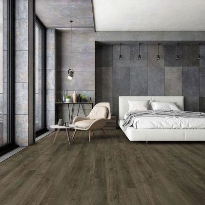 A bedroom with hardwood floors , a bed , a chair and a table.