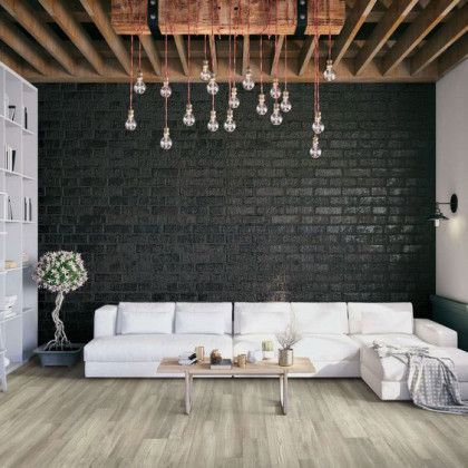 A living room with a couch , coffee table , and brick wall.