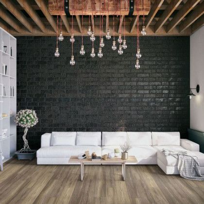 A living room with a couch , coffee table , and brick wall.