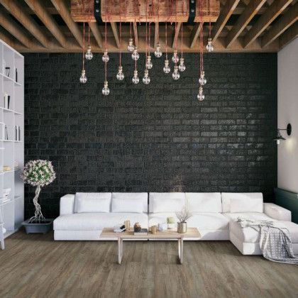A living room with a couch , coffee table , and brick wall.