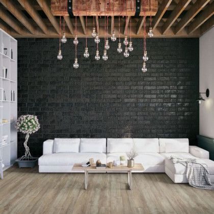 A living room with a couch , coffee table , and brick wall.