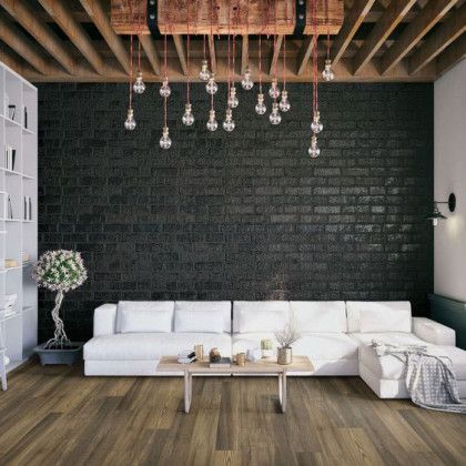 A living room with a couch , coffee table , and brick wall.