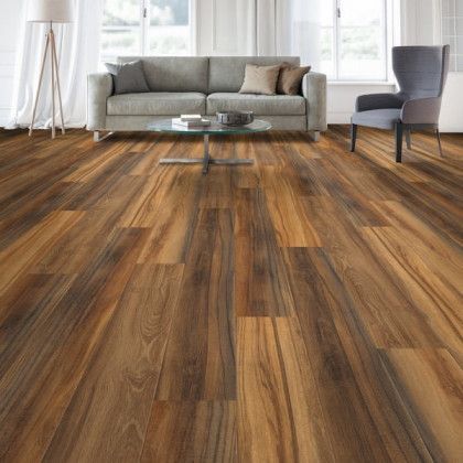 A living room with hardwood floors , a couch , chair and table.