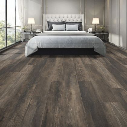 A bedroom with hardwood floors and a bed.