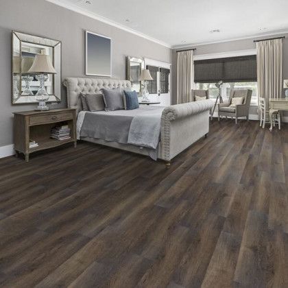 A bedroom with hardwood floors and a large bed
