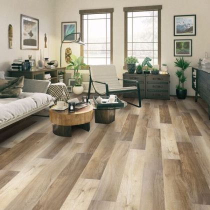 A living room with hardwood floors , a couch , chairs , and a coffee table.