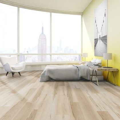A bedroom with a bed , chair , nightstand and large windows.