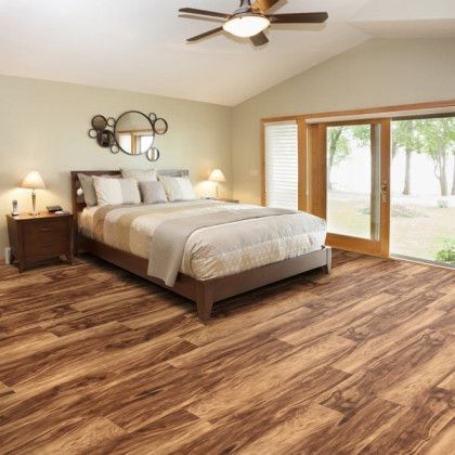 A bedroom with a bed , nightstand , and ceiling fan.