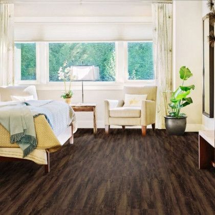 A bedroom with a bed , chair , table and window.