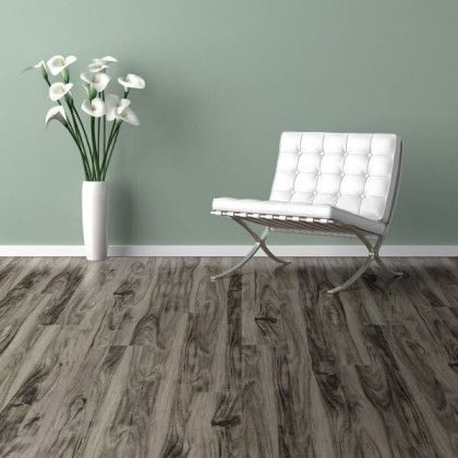 There is a chair and a vase of flowers on the floor.