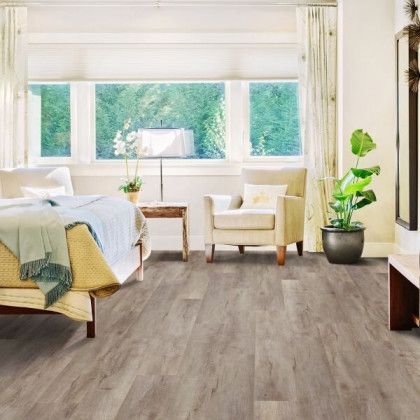 A bedroom with a bed , chair , table and window.