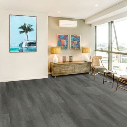A living room with a gray floor and a picture of a van on the wall.