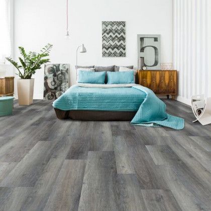 A bedroom with a bed and a gray floor.