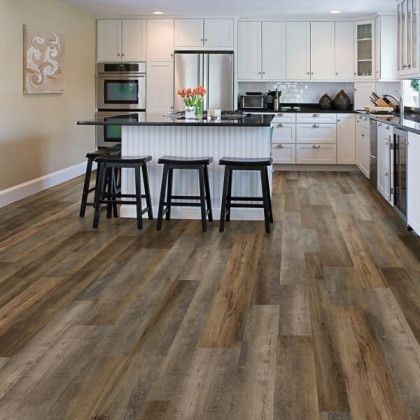 A kitchen with hardwood floors and white cabinets and stools.