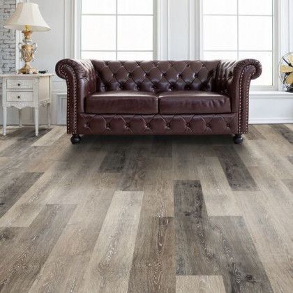 A living room with hardwood floors and a brown leather couch.