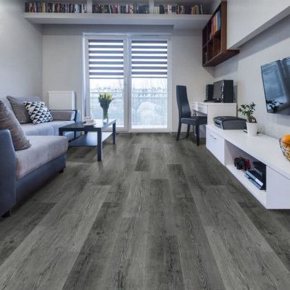A living room with hardwood floors , a couch , a table and a television.