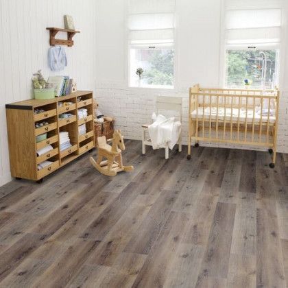 A nursery with hardwood floors , a rocking horse , a crib and a dresser.