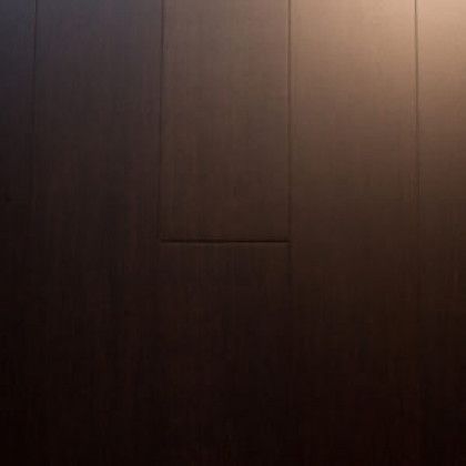 A close up of a dark wooden floor with a light shining on it.
