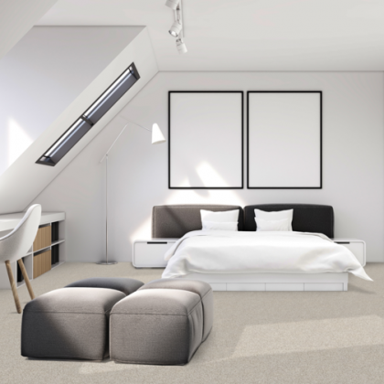 A bedroom with a large bed and two ottomans