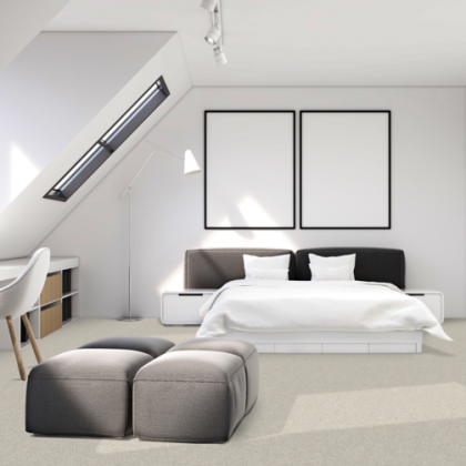 A bedroom with a large bed and two ottomans