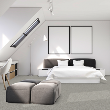 A bedroom with a large bed and two ottomans