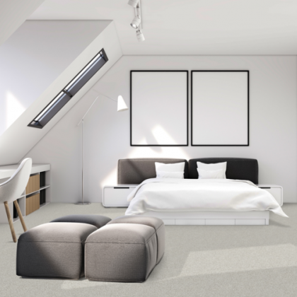 A bedroom with a large bed and two ottomans