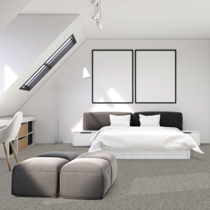 A bedroom with a large bed and two ottomans